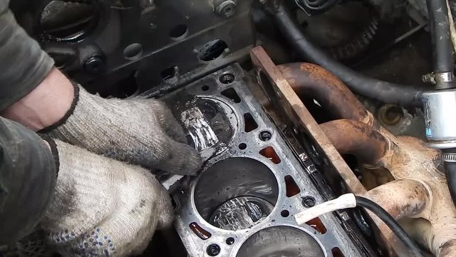 Engine cylinder block. Cleaning the pistons from carbon deposits.