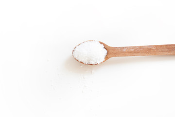 Wooden spoon with salt on white background. Kitchen utensils and spices