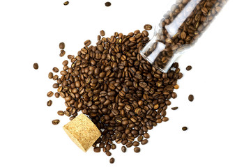 top view of scattered coffee beans from glass bottle and cork isolated on white