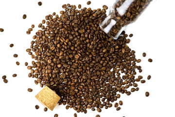 top view of scattered coffee beans from glass bottle and cork isolated on white