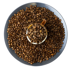 cup full of coffee beans and a plate with coffee beans isolated on white. Top view