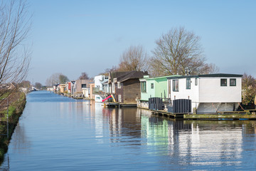 Fototapeta na wymiar Traditional houseboats float on the water of a canal in Holland