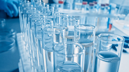 Scientific Laboratory: Pipette Dropping Liquid into Test Tubes, Medical Research and Analysis. Moving Pharmaceutical Production Line; Dropper Fills Sample Tubes used for DNA Study. Close-up Macro