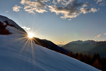 sun hiding behind the orobic Alps