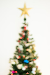 Defocused christmas background. Christimas tree, star, decoration and lights 