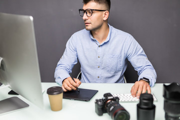Young handsome man photo editor using graphics tablet in office