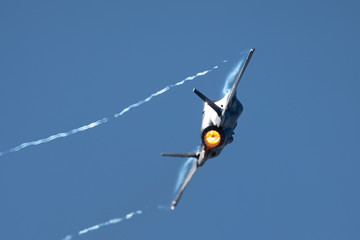 F-35 Lightning II in a tight turn, with afterburner on and condensation trails at the wing’s tips