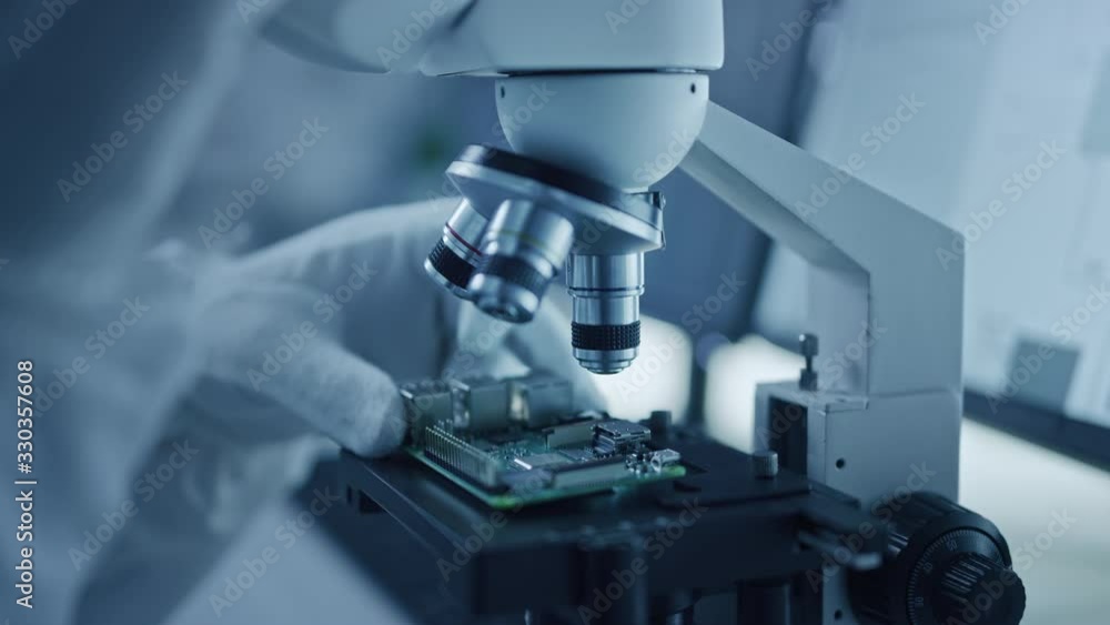 Aufkleber Research Factory Cleanroom: Close-up of Engineer / Scientist wearing Coverall and Gloves Use Microscope to Inspect Motherboard Microprocessor Component, Developing High Tech Modern Electronics