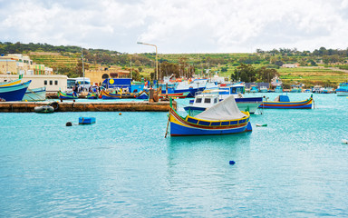 Fototapeta na wymiar Luzzu colored boats at Marsaxlokk Harbor Malta