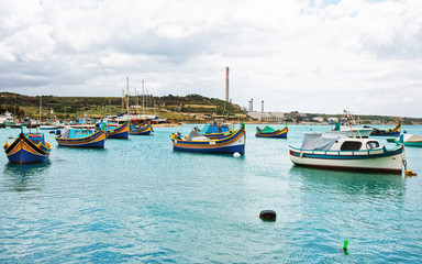 Fototapeta na wymiar Luzzu colored boats at Marsaxlokk Harbor of Malta