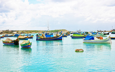 Fototapeta na wymiar Luzzu colorful boats at Marsaxlokk Bay in Malta
