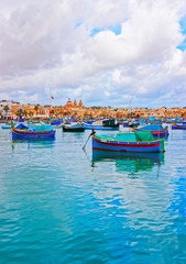 Fototapeta na wymiar Luzzu boats in Marsaxlokk harbor in bay Mediterranean sea Malta