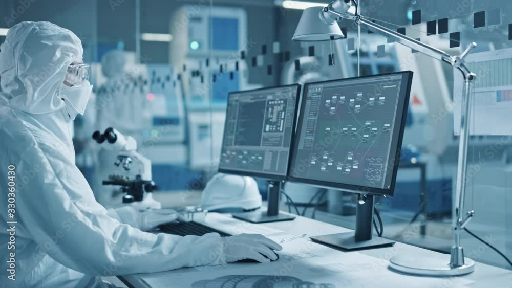 Poster Electronics Factory Cleanroom: Engineer / Scientist in Coveralls Wors on Computer, Screen Shows Infographics and Software System Control UI, Developing Electronics for Medical Electronics