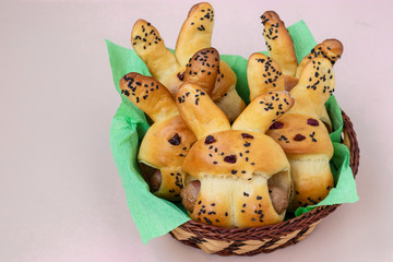 Easter Buns in the form of hares are located in a wicker basket on a light background, culinary idea for children