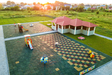 Aerial view of new alcove in kindergarten play yard with red tiled roof for outdoor children...