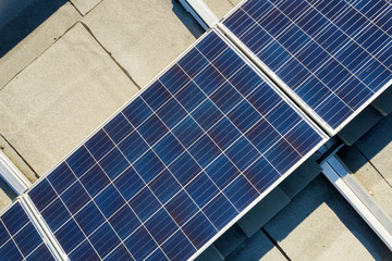 Obraz premium Aerial view of many photo voltaic solar panels mounted of industrial building roof.