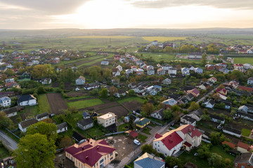 Aerial landscape of small town or village with rows of residential homes and green trees.