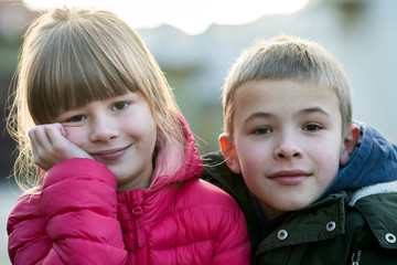 Two children boy and girl fooling around having fun together outdoors on sunny fall day. Happy...