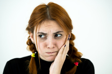 Young woman holding her hand to cheek having toothache.