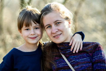 Young mom and her daughter girl together outdoors.