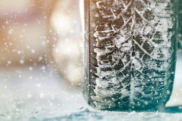 Close-up of car wheels rubber tires in deep winter snow. Transportation and safety concept.