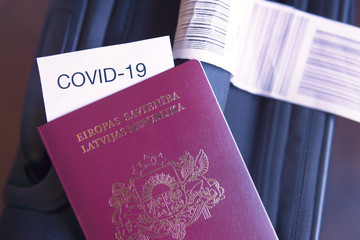 Coronavirus and travel concept. European Union passport, note COVID-19 and a suitcase in airport. Corona virus outbreak. The spread of epidemic, pandemic. Border control .Closed countries borders.