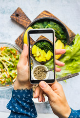 Make phone picture of food. Smartphone photography of vegan, vegetarian lunch, dinner at kitchen, cafe.  Woman hands