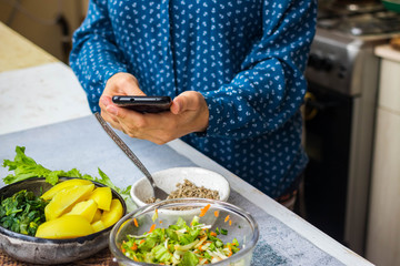 Make phone picture of food. Smartphone photography of vegan, vegetarian lunch, dinner at kitchen, cafe.  Woman hands