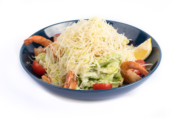 Caesar salad with shrimp on a white plate for menu and web