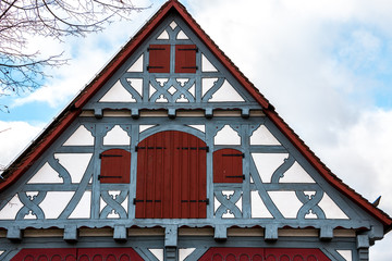 Old historical building with blue wooden beams and red windows and red doors