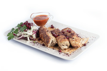 Kebab with red sauce and fresh vegetables on a white plate for menu and web