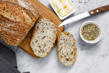 Bread and butter on white marble table. Fresh sliced bread and organic butter for breakfast. Rustic sourdough bread.