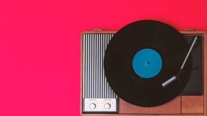 Retro vinyl player and record player on a red background