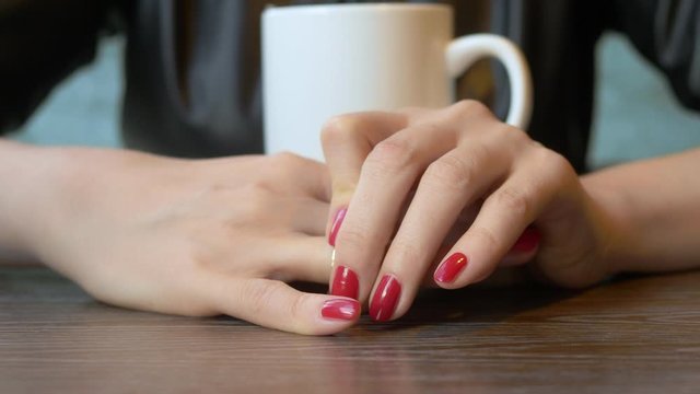 closeup. the woman takes off her wedding ring sitting in a cafe