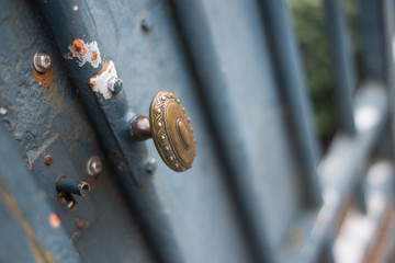 Closeup of vintage handle on metallic grid on building facade in the street
