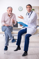 Young male doctor and old patient in antismoking concept