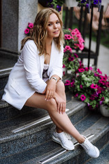 Obraz premium beautiful girl in a white jacket in the city. blonde woman posing