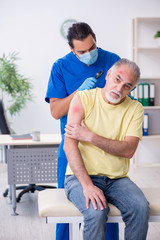 Obraz premium Injured old man visiting young male doctor traumatologist