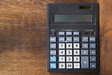 Black calculator on a dark wooden background