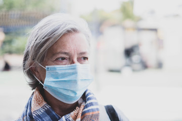 close up of face of mature woman looking away wearing medical mask prevention coronavirus or covi-19 or another type of virus - senior seriously worried and prevention be infected