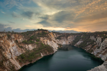Landscape view of limestone quarry with high cliffs and canyons, and water	