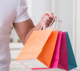 Young man with gift bag at home preparing suprise for wife