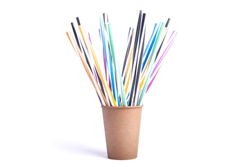 Colored paper cup with straws similar to a rainbow with many multi colored cocktail tubes on a white background
