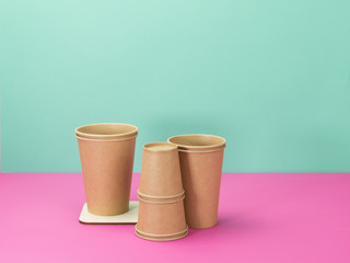 Cups of natural materials, turquoise and pink background.