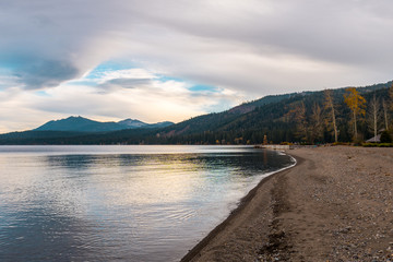 Sunset view of the shore, the dock and the hill full of pines in Lake Tahoe