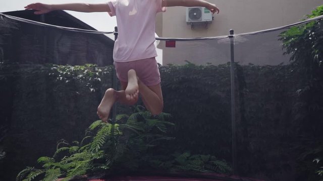 A girl jumping on a trampoline in slow motion