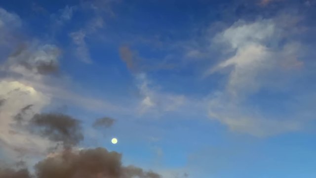 Time lapse of clouds and moon in the sky on sunny day