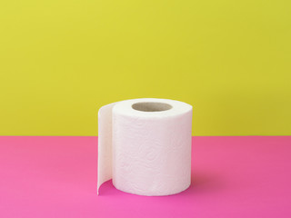 Toilet paper on a pink and green background.