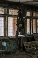 Fototapeta na wymiar Gas mask hanging from the ceiling of an abandoned room