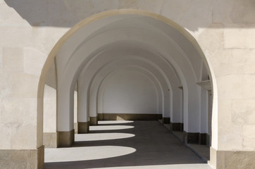 Hallway to a building with arches and shadow play